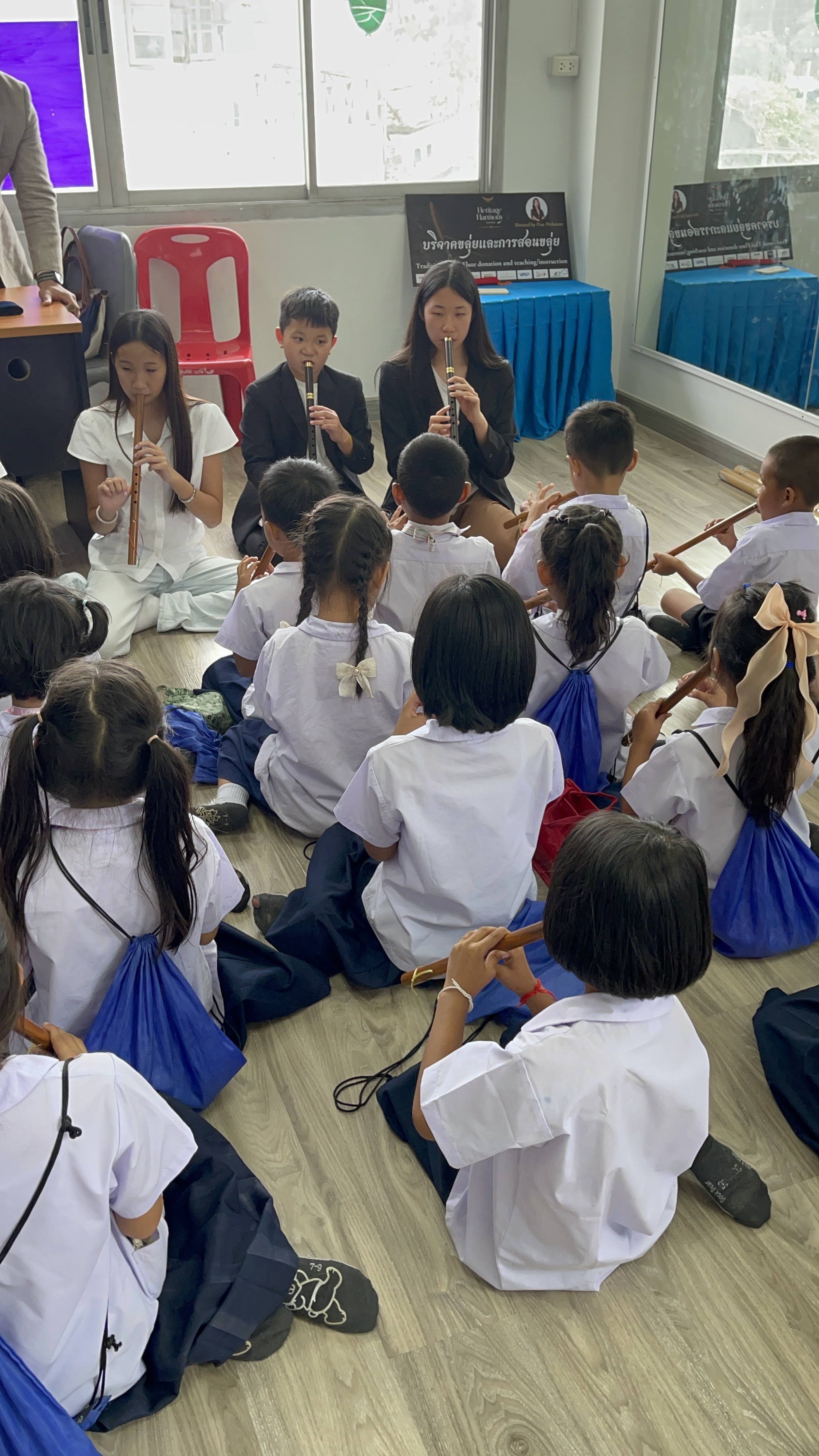 เยาวชนสาธิตการเป่าขลุ่ยให้กับนักเรียนรุ่นเล็ก